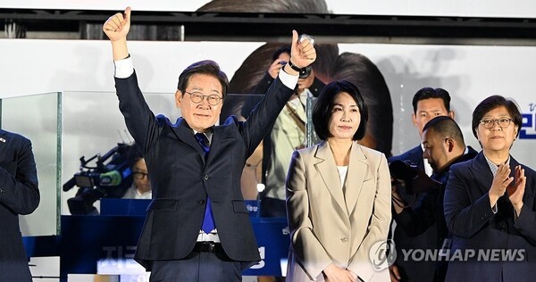  제21대 대통령 당선이 확실시되는 더불어민주당 이재명 대선 후보와 부인 김혜경 여사가 4일 서울 여의도 국회 인근에서 당 주최로 열린 국민개표방송 행사에 참석해 시민들을 향해 두 팔을 들어 인사하고 있다. 2025.6.4/연합뉴스