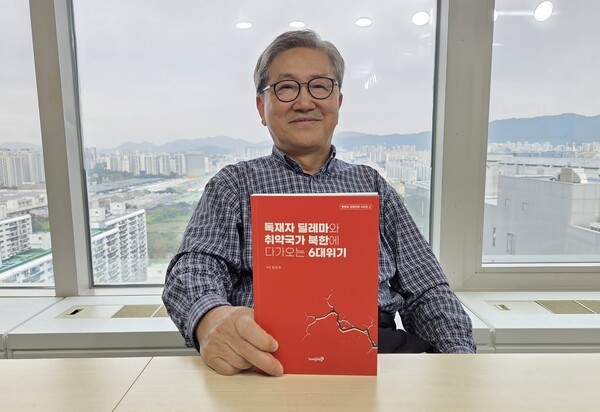 김진무 박사가 21일 서울 강남구 샌드타임즈 사무실에서 인터뷰를 진행하며 자신의 저서를 들어 보이고 있다./샌드타임즈